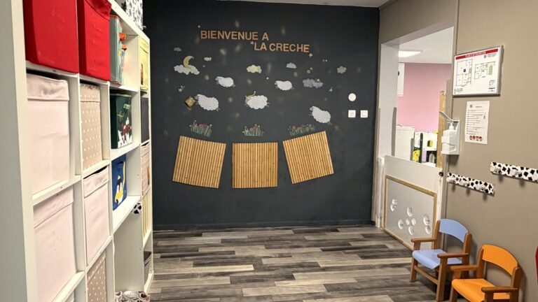 L'entrée de la crèche, avec le mur « Bienvenue à la crèche » et les petites chaises